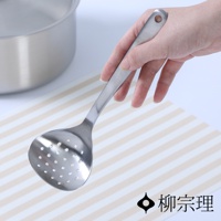 一只手正拿著一個不鏽鋼圓孔杓，杓面有許多圓形小孔，杓柄末端有個掛孔。