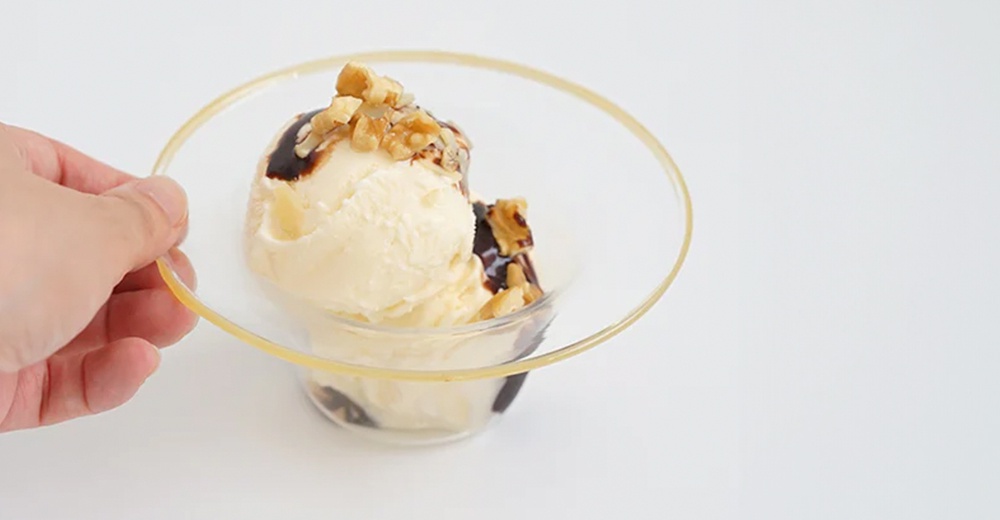 透明玻璃點心碗，盛裝著香草冰淇淋、巧克力醬及堅果碎，碗呈圓形深型，邊緣帶有細緻的金色。