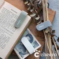 淺綠色、灰色和米白色萬能QQ變形夾，皆印有白色「cheero」字樣，其中淺綠色夾子夾在打開的書籍上，灰色夾子放在乾燥植物旁，米白色夾子則疊在日圓鈔票上。