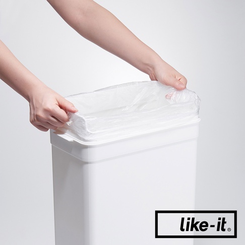 雙手正在為白色塑膠垃圾桶套上透明垃圾袋。