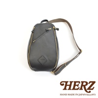 黑色皮革職人手作多功能收納斜背包，正面有斜向拉鍊開口及品牌菱形壓紋，搭配黃銅色拉鍊與可調節式深棕色織帶。