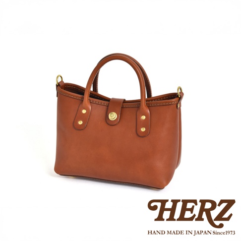 職人手作皮革迷你托特包，棕色皮革，配有金色金屬釦和铆釘，雙提把設計，簡約實用。