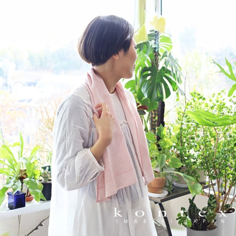 MOKU ORGANIC 有機棉食材染料長毛巾，淡粉色，材質柔軟，帶有細條紋紋理，圍繞在一位女性頸部。