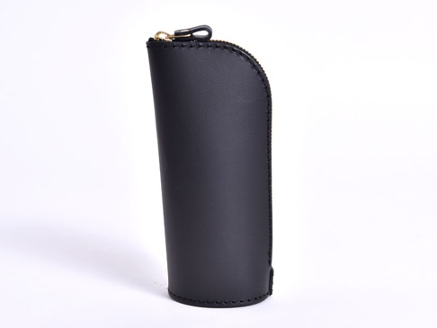 職人手作皮革直立式收納筆袋，黑色光滑皮革材質，頂部有金色拉鍊，整體呈現簡潔的長筒狀設計。
