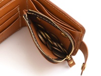 職人手作皮革Titi wallet，展示棕色皮革短夾，內含可拆式零錢袋，拉鍊與釦環皆為黃銅色，部分零錢置於袋內。