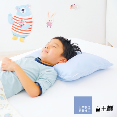 一個男孩躺在淡藍色枕頭上，枕頭放在白色床單上。背景牆上有卡通熊和兔子裝飾。