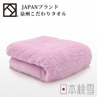 一條粉紅色加厚浴巾，材質柔軟，質地蓬鬆，呈現溫暖的觸感。