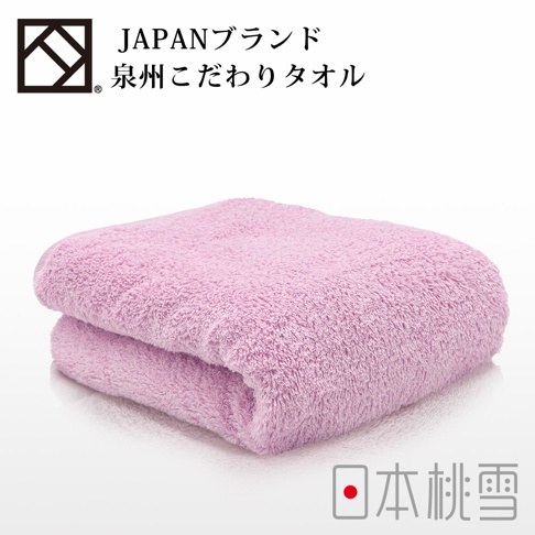 一條粉紅色加厚浴巾，材質柔軟，質地蓬鬆，呈現溫暖的觸感。