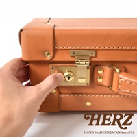 職人手作皮革英倫風便攜手提行李箱，採用 tan 色牛皮製成，配有黃銅色鎖頭和金屬扣件，細膩車縫線展現精緻工藝。