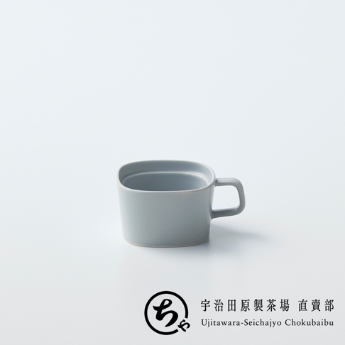 一個淡灰色的美濃燒馬克杯置於純白背景中央，杯身呈現帶有圓角的方形設計，搭配簡約的方形把手，右下角印有宇治田原製茶場的圓形品牌標誌及對應的中英文名稱。