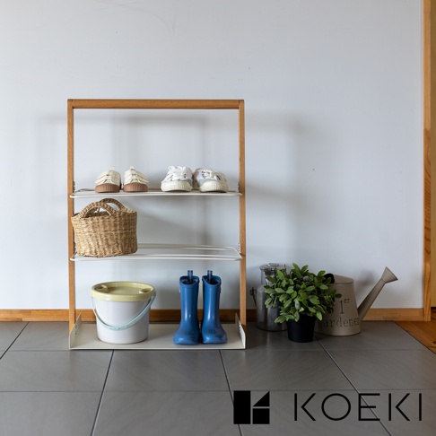 Mash 手提式萬用鞋靴收納架，木質框架搭配白色層架，收納架上擺放著白色運動鞋、編織籃、白色水桶、藍色雨靴及綠色盆栽，整體設計簡潔實用。