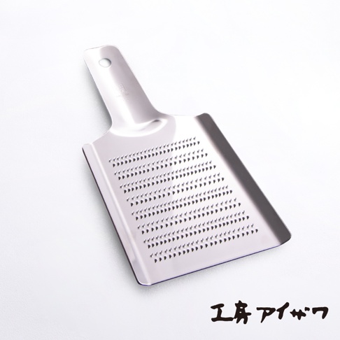 銀色不鏽鋼製的食材磨泥器，帶有手柄和密集的磨孔，用於研磨食材。