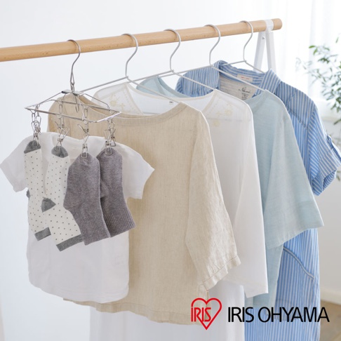 銀色金屬曬衣架，掛有兩雙白色點點襪子、兩雙灰色襪子、一件米色亞麻短袖上衣、一件白色上衣、一件淺藍色上衣，以及一件藍白條紋襯衫。