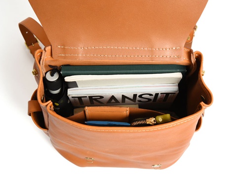 職人手作皮革屋瓦風經典雙扣後背包 (R-153)，棕褐色皮革，內部裝有雜誌、書籍、筆、鑰匙和錢包。