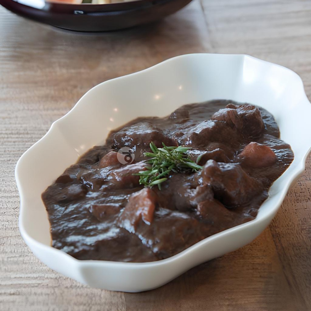 淡青白釉美濃燒輪花長盤盛有濃郁的燉牛肉，撒有迷迭香點綴。