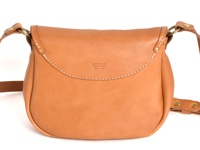 一款淺棕色皮革製成的馬鞍包，帶有翻蓋設計和縫線細節，配有可調節的皮革肩帶和金屬搭扣。