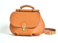 棕褐色皮革製成的迷你後背包，附有翻蓋式開口、黃銅旋轉鎖扣及可調整式皮革背帶。
