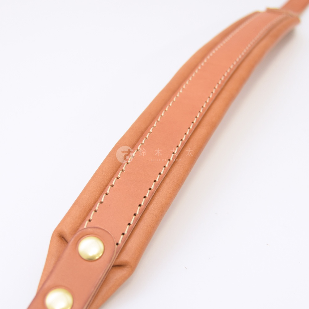 職人手作皮革加厚減壓肩背帶，呈現自然棕色，由光滑皮革與柔軟內襯組成，縫線整齊，配有金色金屬釦。