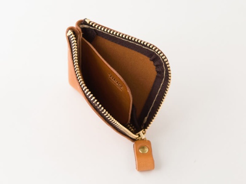 淺棕色皮革製成、拉鍊打開的零錢包，內部有兩個隔層，外側有一個皮革拉環。