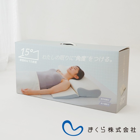 淺藍色包裝盒上印有女性仰躺於白色與淺灰色相間的15度半身枕的插圖，枕頭形狀符合人體工學，包裝盒左上方有「15°」的標誌及日文說明。