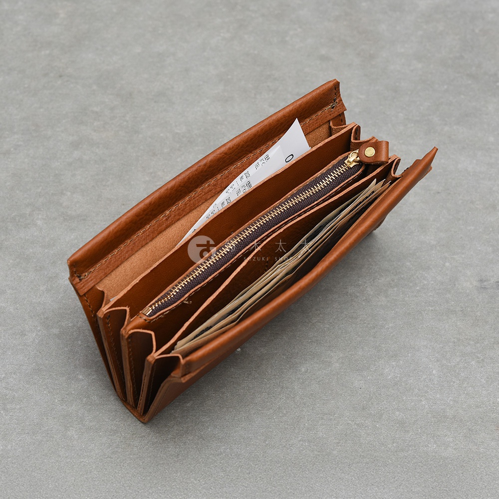 一個由日本HERZ職人手作的棕色皮革長夾，呈現開放式的長夾內部結構，材質為溫潤的天然植鞣革，具備多個風琴褶層收納空間與一個帶有金屬拉鍊的零錢袋，整體設計風格簡約且實用。