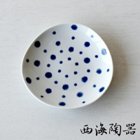 白色陶瓷醬料碟，佈滿藍色不規則圓點紋飾，碟面略有凹陷，適合盛裝醬料。