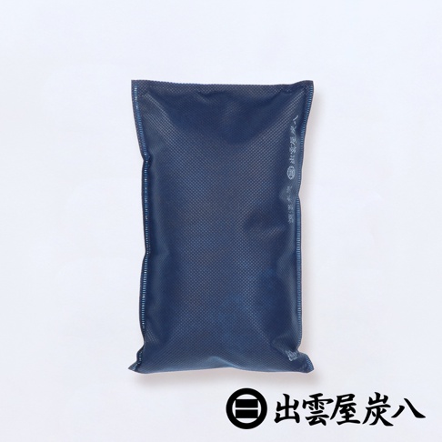 一個深藍色、寬版、長方形的調濕木炭包，表面有細小網格紋路，邊緣有縫線。右側有黑色日文商標。