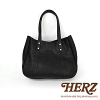 黑色皮革仕女托特包，雙提把設計，包身有縫線裝飾，兩個金色鉚釘固定提把，簡約大方。