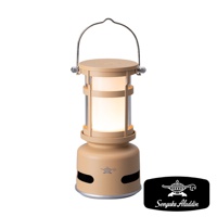 奶茶色神燈造型音箱，附帶可提式金屬提把，燈罩為透明材質，內部散發溫暖燈光，底部有品牌Logo和喇叭孔。