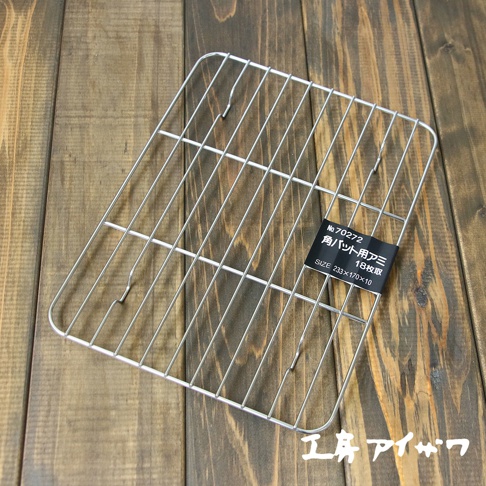 方形不鏽鋼瀝油架，銀色金屬材質，網格狀設計，帶有黑色標籤，標示產品編號、名稱及尺寸。