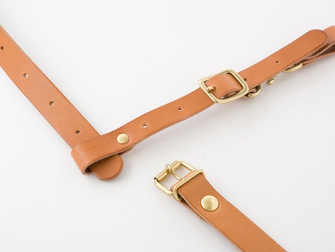 職人手作皮革背包用胸前扣帶，寬 3 公分，採用天然棕色皮革製成，配有黃銅色插扣和铆釘，可調節長度。