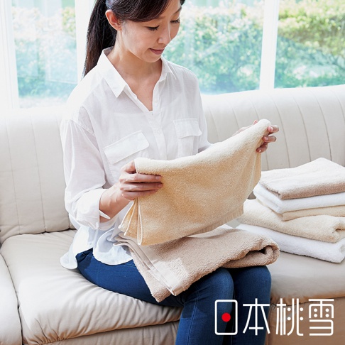 展示女性手持淺米色方巾，旁邊疊放著白色、淺褐色和米色的方巾，方巾材質蓬鬆柔軟。