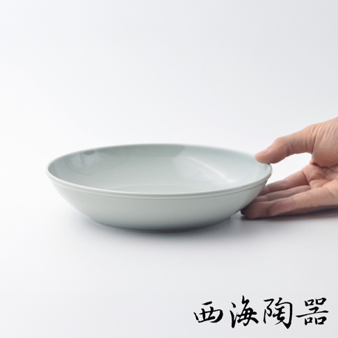 淺綠色波佐見燒Common陶瓷料理深碗，直徑21公分，手部輕觸碗緣，展現其簡約的設計與細膩的質感。