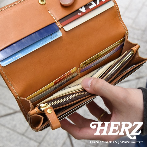 職人手作皮革軟皮長夾，棕色皮革內有卡槽、鈔票夾層，搭配黃銅色拉鍊，展示多張信用卡與日幣現金。