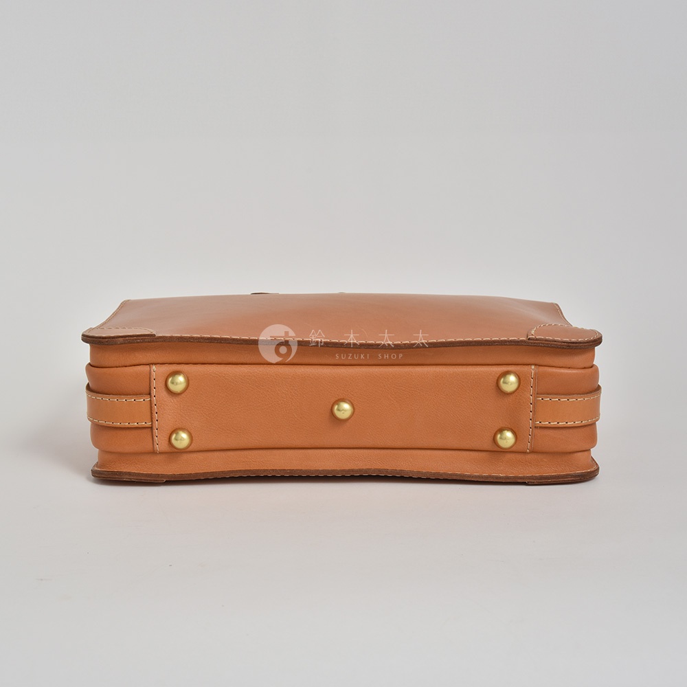 職人手作淺棕色皮革三層商務公事包，側面可見金色鉚釘裝飾，縫線清晰，材質為皮革。