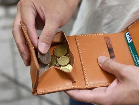 棕色皮革三折式迷你短夾，內有零錢袋裝有多枚硬幣，以及兩個卡槽，其中一個卡槽插有VISA金融卡。