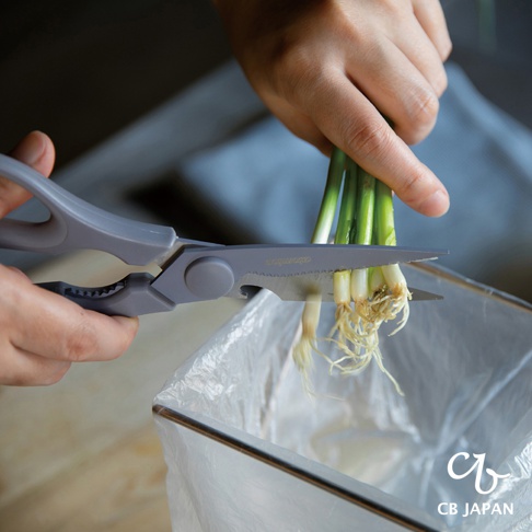 CB JAPAN atomico 系列廚房不沾剪刀正在修剪帶有根系的青蔥，青蔥的根部被放入一個透明的塑膠袋內。