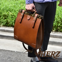 棕色皮革復古口金後背包，配有黃銅色金屬配件和可調節的皮革肩帶，由手工製作。