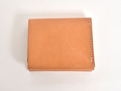 淺棕色皮革製成的職人手作雙折短夾，直式設計，兩側縫線清晰可見，簡潔大方，適合收納卡片。