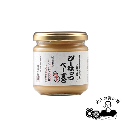 玻璃罐裝柔滑花生醬，金黃色瓶蓋，標籤上印有日文，內容物為淺棕色醬狀物。