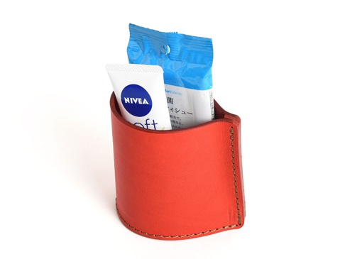 紅色職人手作皮革筆筒，側邊縫線明顯，內有 NIVEA SOFT 乳液小條及一包藍色包裝濕紙巾。
