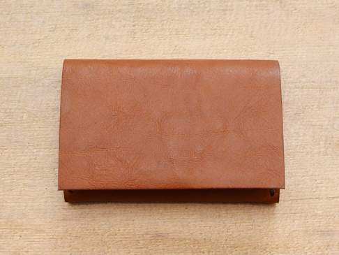 職人手作皮革Organ薄型名片短夾 (GS-49)，呈長方形，以棕褐色皮革製成，表面有細緻紋理，置於淺色木紋背景上。
