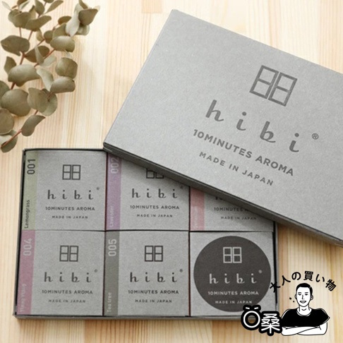 灰色的禮盒內含五組香氛火柴，每組獨立小盒包裝，印有「hibi 10MINUTES AROMA MADE IN JAPAN」字樣及品牌標誌。小盒顏色從左至右為綠、紫、粉紅、淺紫、灰，分別標示001至005號。