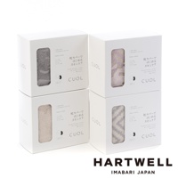 四個白色方形紙盒堆疊展示，每個紙盒的透明窗口中可見不同顏色的CUOL今治柔彈伸縮美肌枕套，分別為灰色、粉紫色、米白色及灰白色相間條紋。