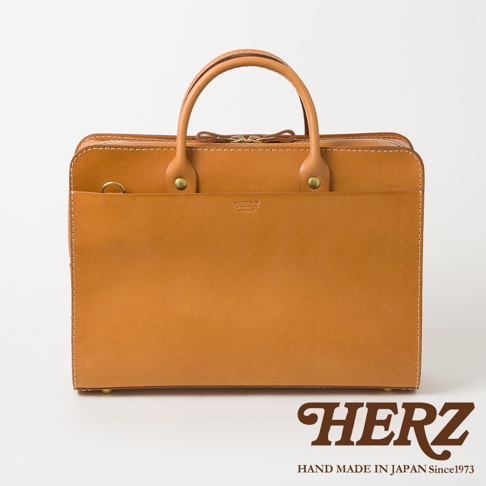 職人手作皮革雙口袋兩用商務公事包，採用光滑棕色皮革製成，配有頂部提把、拉鍊開口及外部開放式口袋，整體設計簡潔大方。