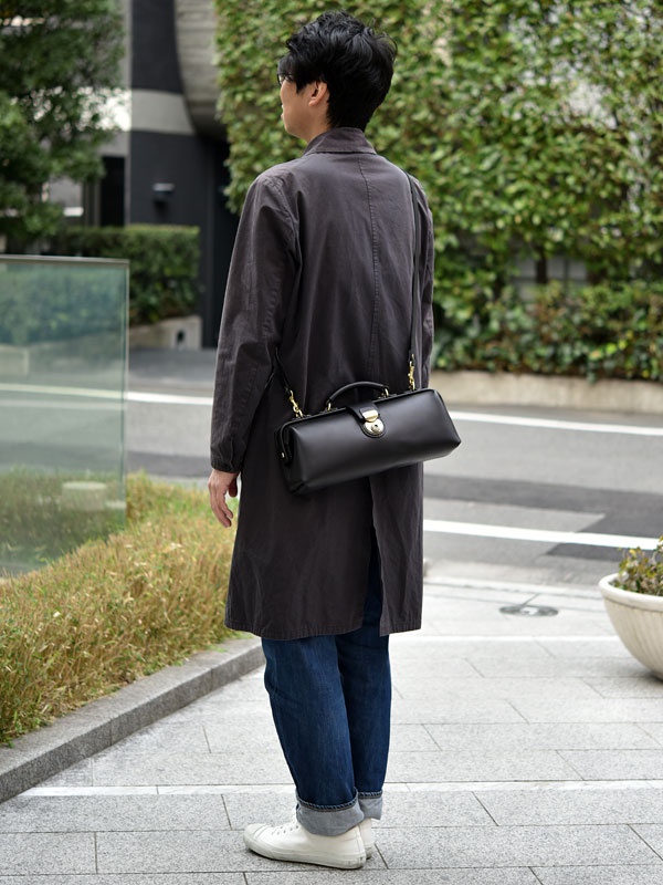 職人手作皮革橫長形杜勒斯單肩包 (CW-4)，黑色光滑皮革，配有金色鎖扣和提把，可斜挎或手提。