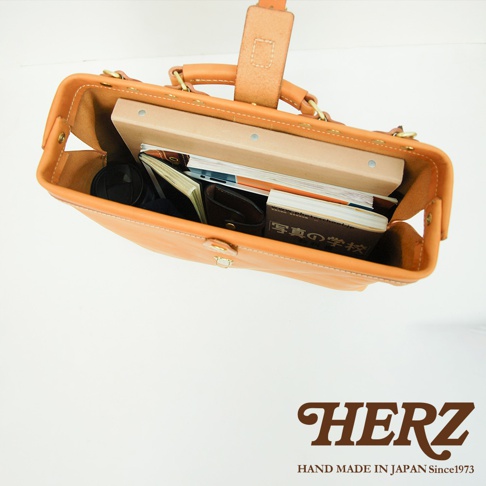 職人手作皮革軟式杜勒斯包，原色皮革材質，包款開口可見內部收納，包含文件、筆記本及其他小物。