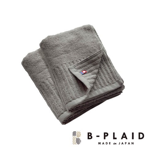 摺疊的灰色毛巾，表面有直條紋理，織有「RIB」字樣的標籤，標籤上有紅色、白色和藍色的圓形圖案。