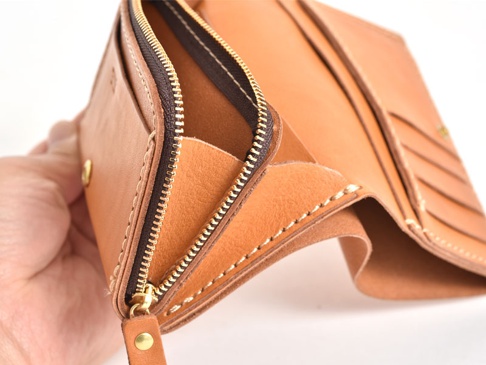 職人手作皮革中型雙折短夾，原色皮革，附金色拉鍊與按扣，內部有多個卡片夾層。