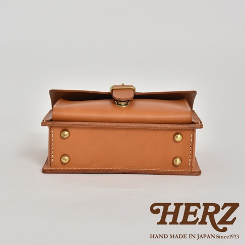 職人手作皮革經典混合風迷你單肩包，採用原色皮革，帶有金色金屬扣環和鉚釘，方形箱體設計，縫線清晰。